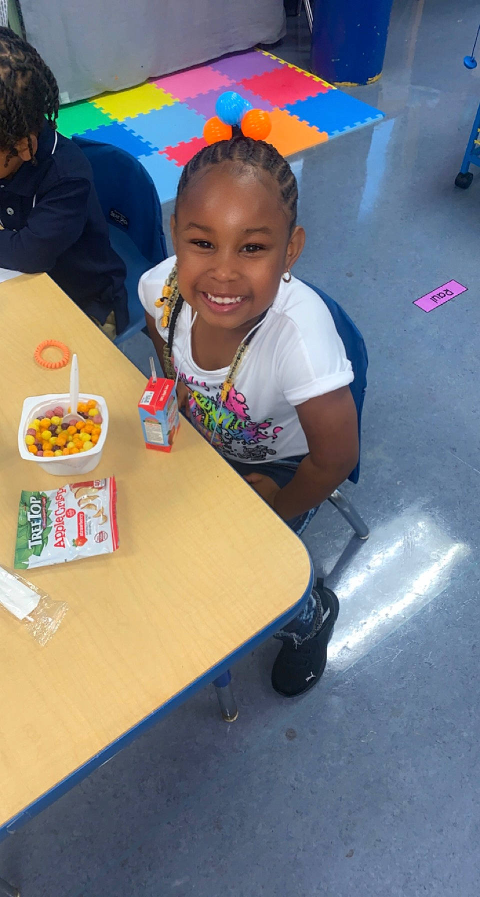 Cieanna is registered to the contest to win money with this photo: chair, child, comfort_food, cuisine, desk, event, finger_food, food, fun, joy, junk_food, kindergarten, leisure, person, plate, recreation, sharing, smile, t_shirt, table