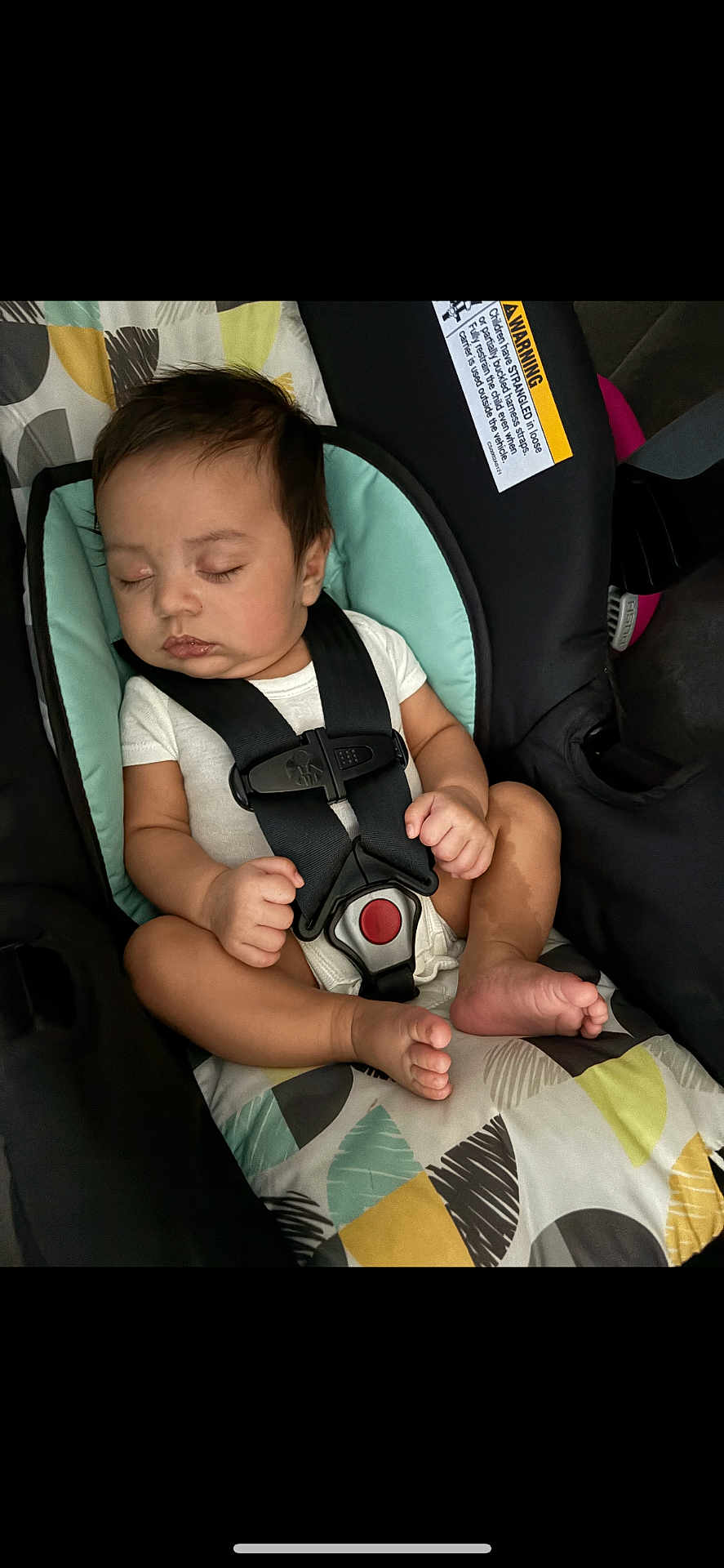 Jahkai is registered to the contest to win money with this photo: baby, sleeping, car_seat, child, infant, straps, seatbelt, cushion, patterned_fabric, white_clothing, peaceful, closed_eyes, small_hands, small_feet, indoors, safety, rest, cute, comfort, person