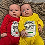 baby, infant, twins, red_onesie, yellow_onesie, blanket, blue_eyes, cute, lying_down, indoors, child, face, portrait, clothing, baby_girls, newborn, soft_texture, warm_colors, sibling, adorable