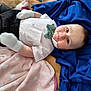Jameson joined the competition — help win amazing prizes! baby, infant, child, blanket, clothing, shirt, bow_tie, mittens, pants, face, eyes, lying_down, soft_texture, pink_blanket, blue_blanket, cute, portrait, indoors, comfortable, young