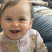 Jocelyn is registered to the contest to win money with this photo: baby, casual, child, clothing, couch, cozy, cute, face, happy, home, indoor, infant, onesie, person, plaid_blanket, portrait, seated, smiling, teddy_bear_pattern, young_child