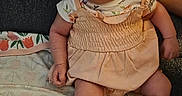 Ariyah is registered to the contest to win money with this photo: arm, baby, blanket, child, clothing, cute, fabric, face, floral_pattern, headwrap, indoors, infant, leg, person, portrait, serious_expression, shoes, sitting, skin, soft_toys
