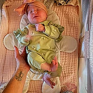 Ariyah joined the competition — help win amazing prizes! newborn, baby, sleeping, green_outfit, headband, bow, hand, tattoo, pink_quilt, plush_padding, crib, baby_essentials, pacifier, soft_lighting, infant, cute, cozy, resting, child, person