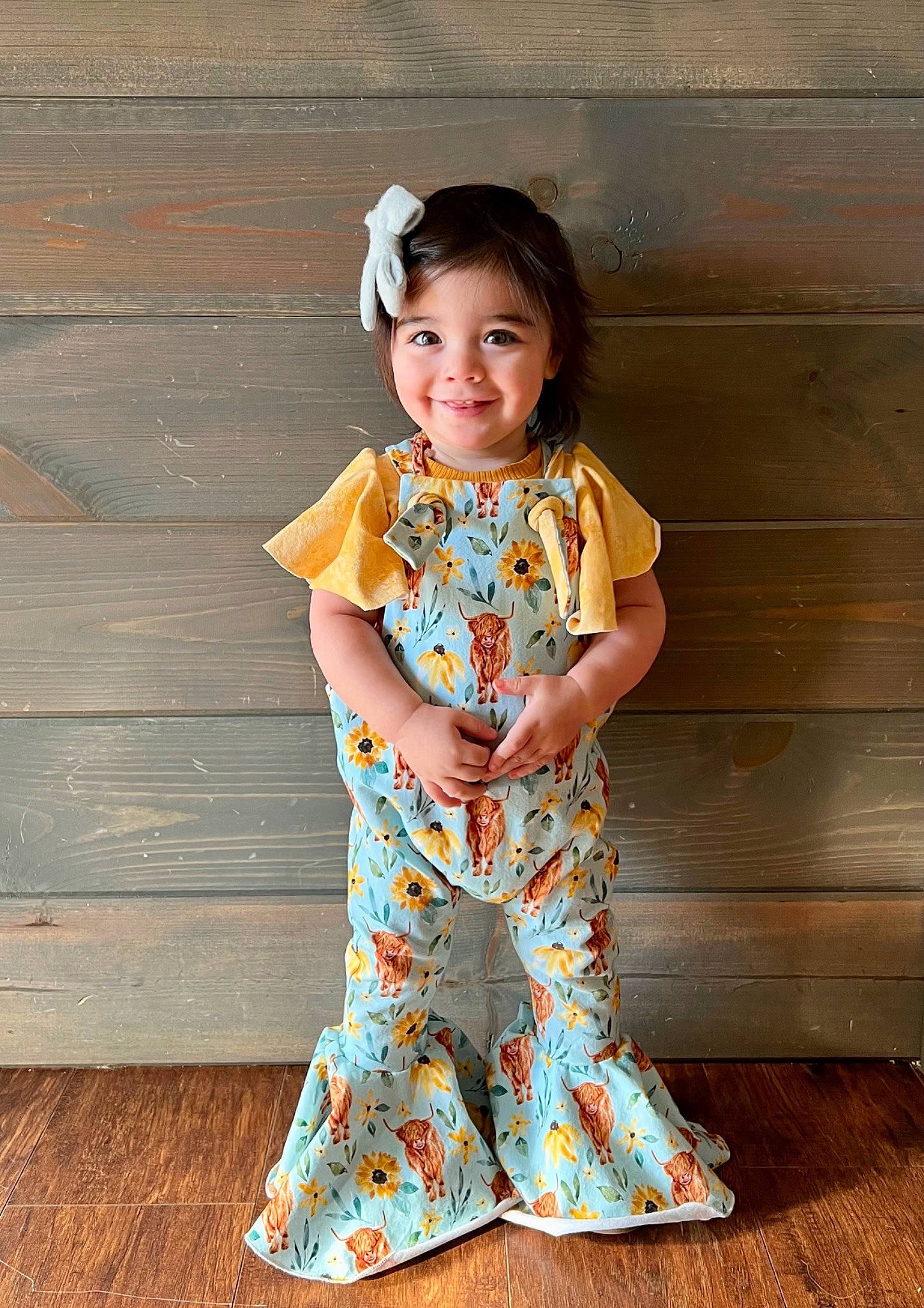 Brexley is registered to the contest to win money with this photo: baby_toddler_clothing, child, day_dress, dress, face, fashion_design, happy, joy, neck, one_piece_garment, outerwear, pattern, peach, person, plant, sleeve, smile, standing, t_shirt, toddler