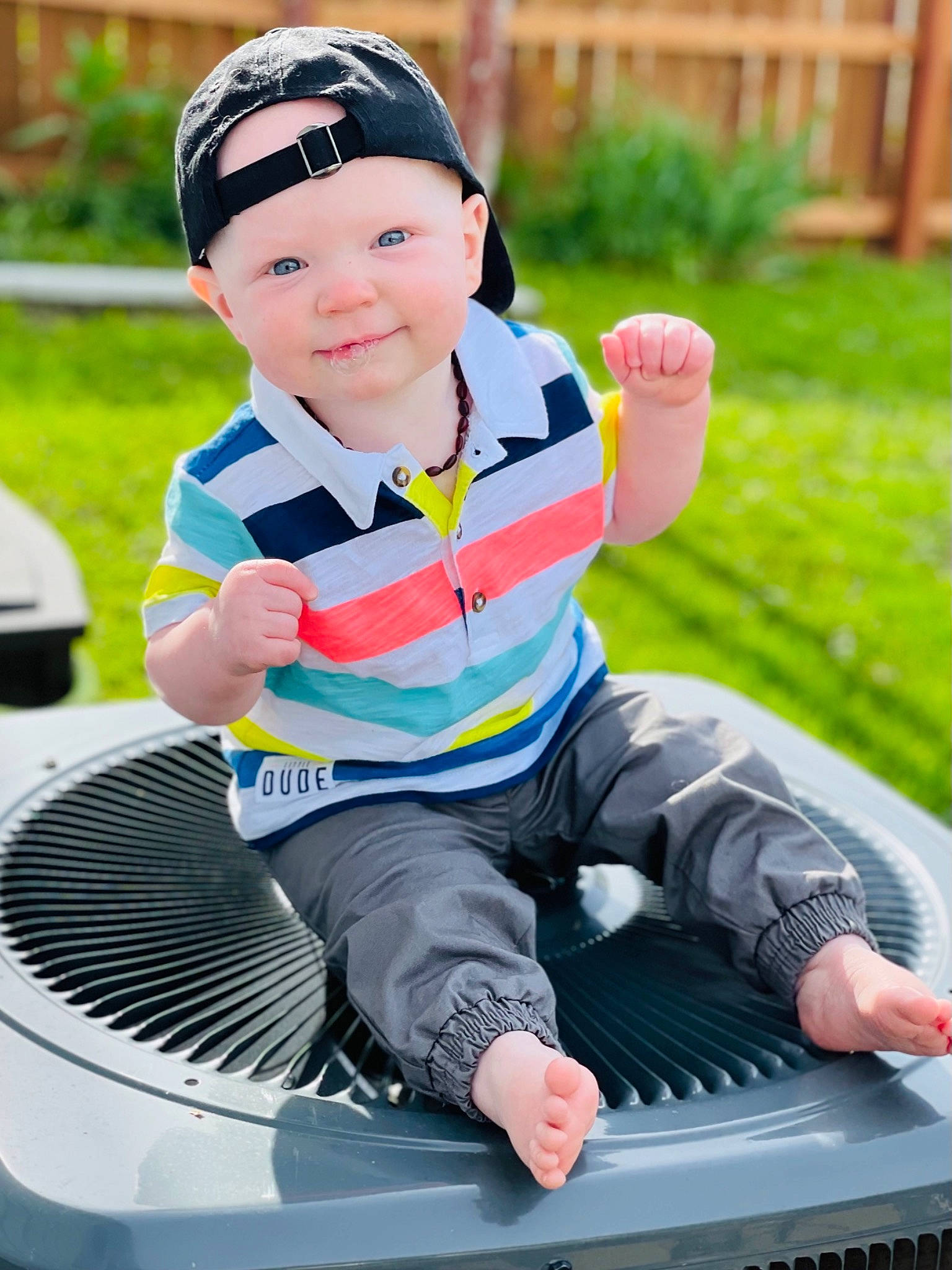 Deegan is registered to the contest to win money with this photo: automotive_tire, baby, baby_toddler_clothing, child, fun, grass, happy, headwear, joy, leisure, person, personal_protective_equipment, plant, recreation, shorts, sitting, sleeve, smile, sneakers, t_shirt