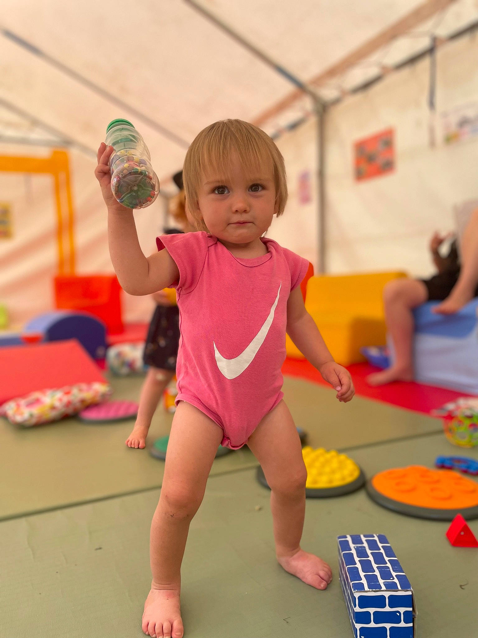 Leïla participe au concours pour gagner de l'argent avec cette photo : baby_toddler_clothing, balance, barefoot, child, flooring, foot, fun, human_leg, leisure, monokini, person, physical_fitness, play, recreation, room, rubiks_cube, shorts, sportswear, t_shirt, thigh