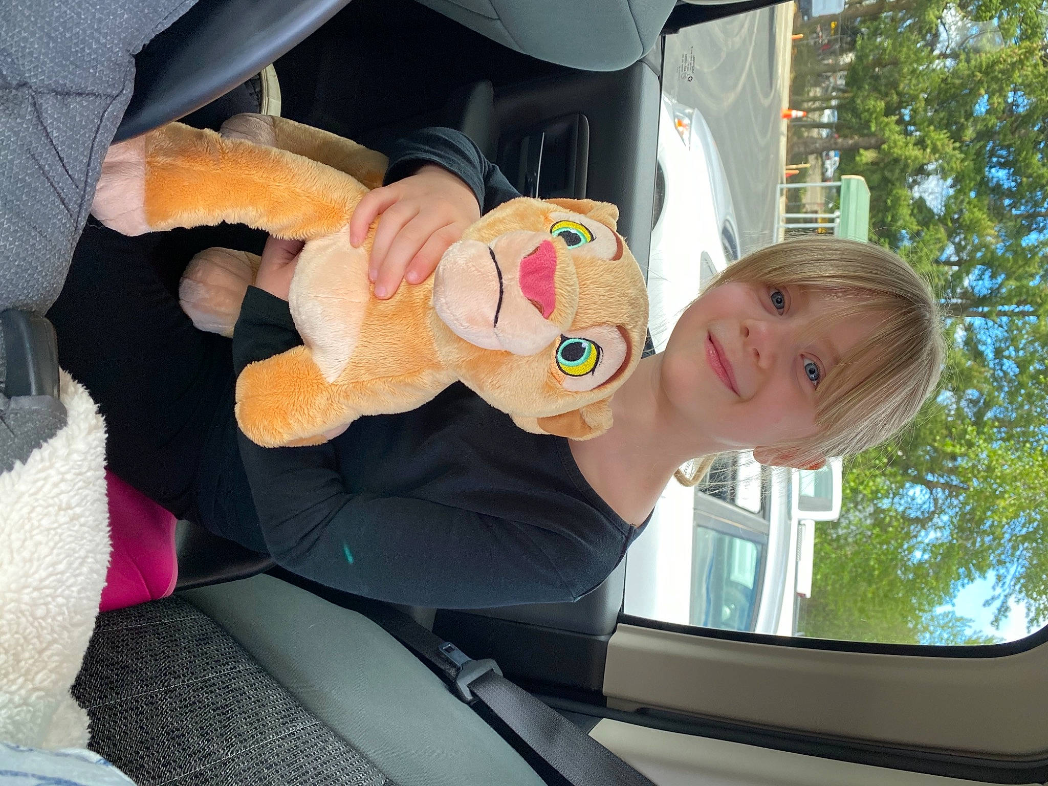 Caylee is registered to the contest to win money with this photo: auto_part, automotive_exterior, baby_products, car, car_seat, child, family_car, fun, gesture, happy, joy, leisure, motor_vehicle, person, sky, stuffed_toy, toddler, toy, tree, vehicle