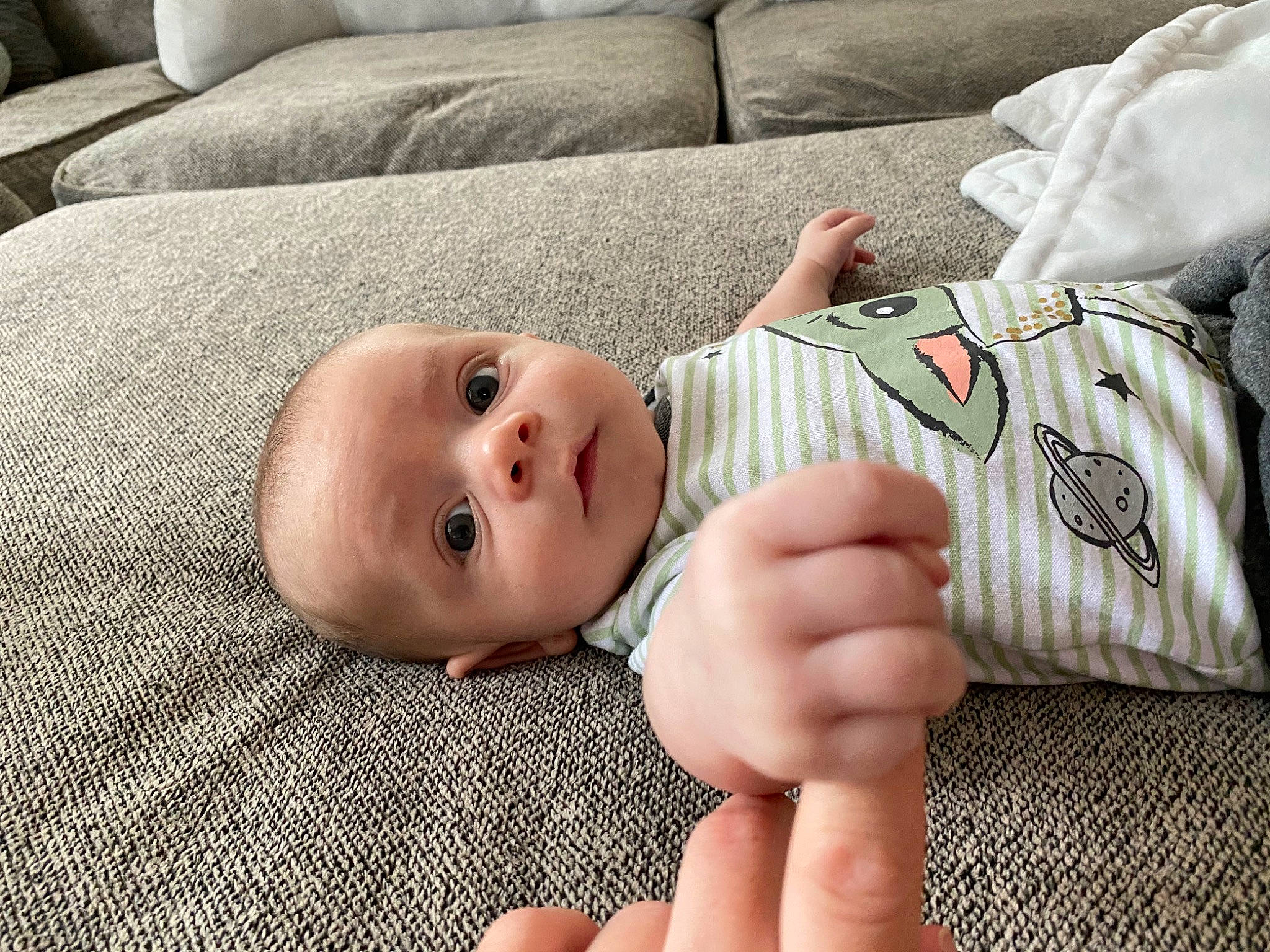 Karson is registered to the contest to win money with this photo: baby, baby_toddler_clothing, cheek, child, comfort, eye, face, finger, gesture, hand, happy, head, human_body, nose, person, skin, sleeve, smile, toddler, vertebrate