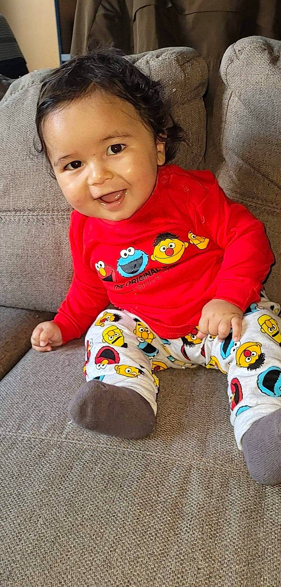 Yliano participe au concours pour gagner de l'argent avec cette photo : baby, baby_toddler_clothing, carmine, cheek, child, comfort, eye, face, flooring, fun, happy, head, pattern, person, product, sitting, skin, sleeve, smile, t_shirt