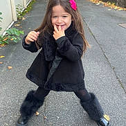 Léna a rejoint le concours — aidez-le/la à gagner de superbes lots ! child, girl, smiling, outdoor, pavement, black_clothing, fur_boots, flower_hair_clip, long_hair, playful, fence, urban, autumn_leaves, happy, cute, posing, daylight, fashion, casual, fun