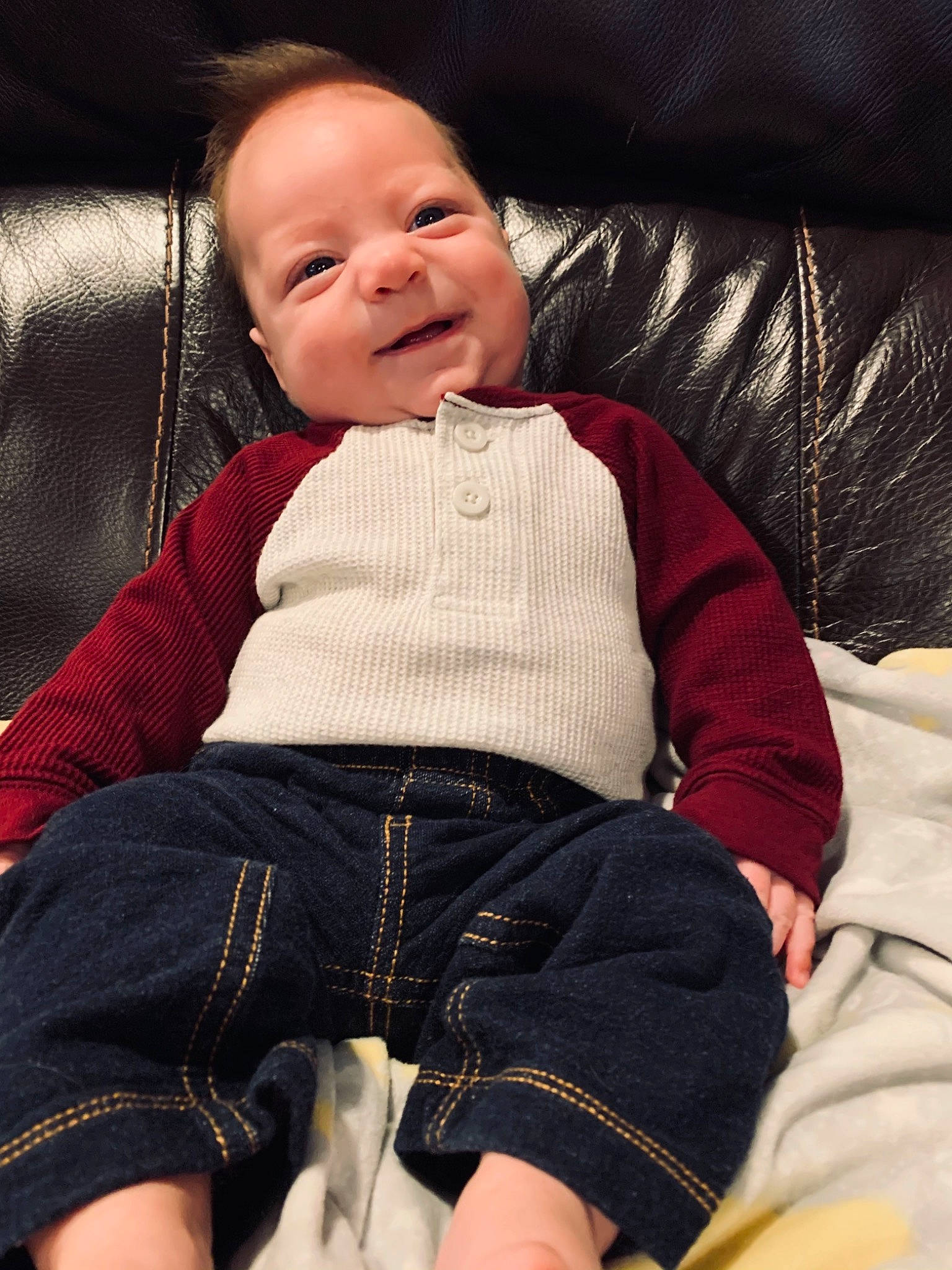 Rustin joined the competition — help win amazing prizes! baby, baby_toddler_clothing, cheek, child, comfort, couch, denim, facial_expression, human_body, lap, laugh, lip, mouth, nose, person, sitting, sleeve, sweater, textile, toddler