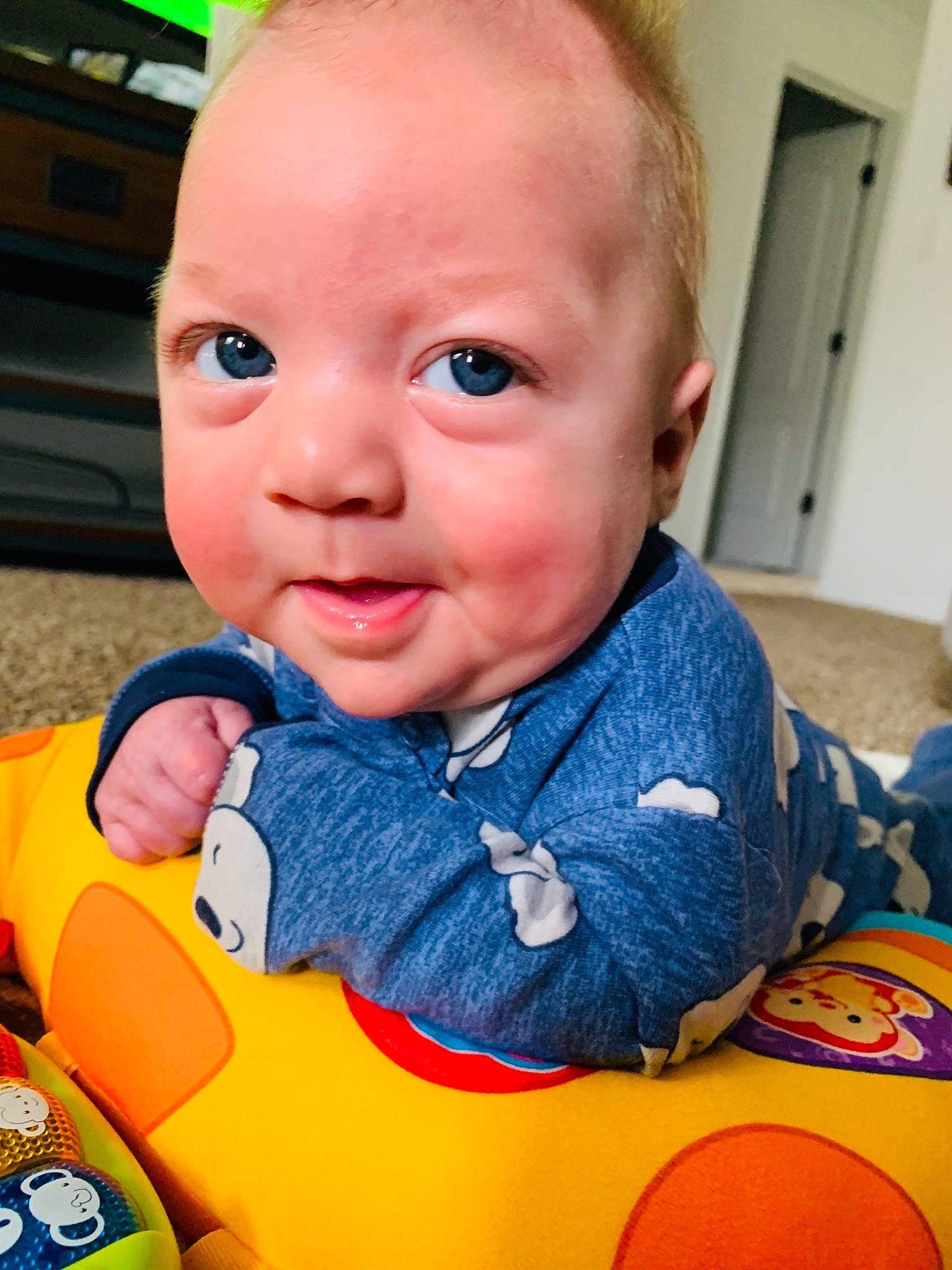Rustin is registered to the contest to win money with this photo: baby, baby_products, baby_toddler_clothing, baby_toys, cheek, child, door, eye, iris, lip, mouth, orange, overall, person, sitting, skin, toddler