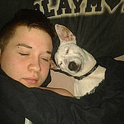 Joy a rejoint le concours — aidez-le/la à gagner de superbes lots ! person, dog, sleeping, bed, blanket, pillow, indoor, resting, closeup, cozy, relaxation, pet, companion, black_blanket, white_dog, short_hair, collar, eyebrow_piercing, face, comfort
