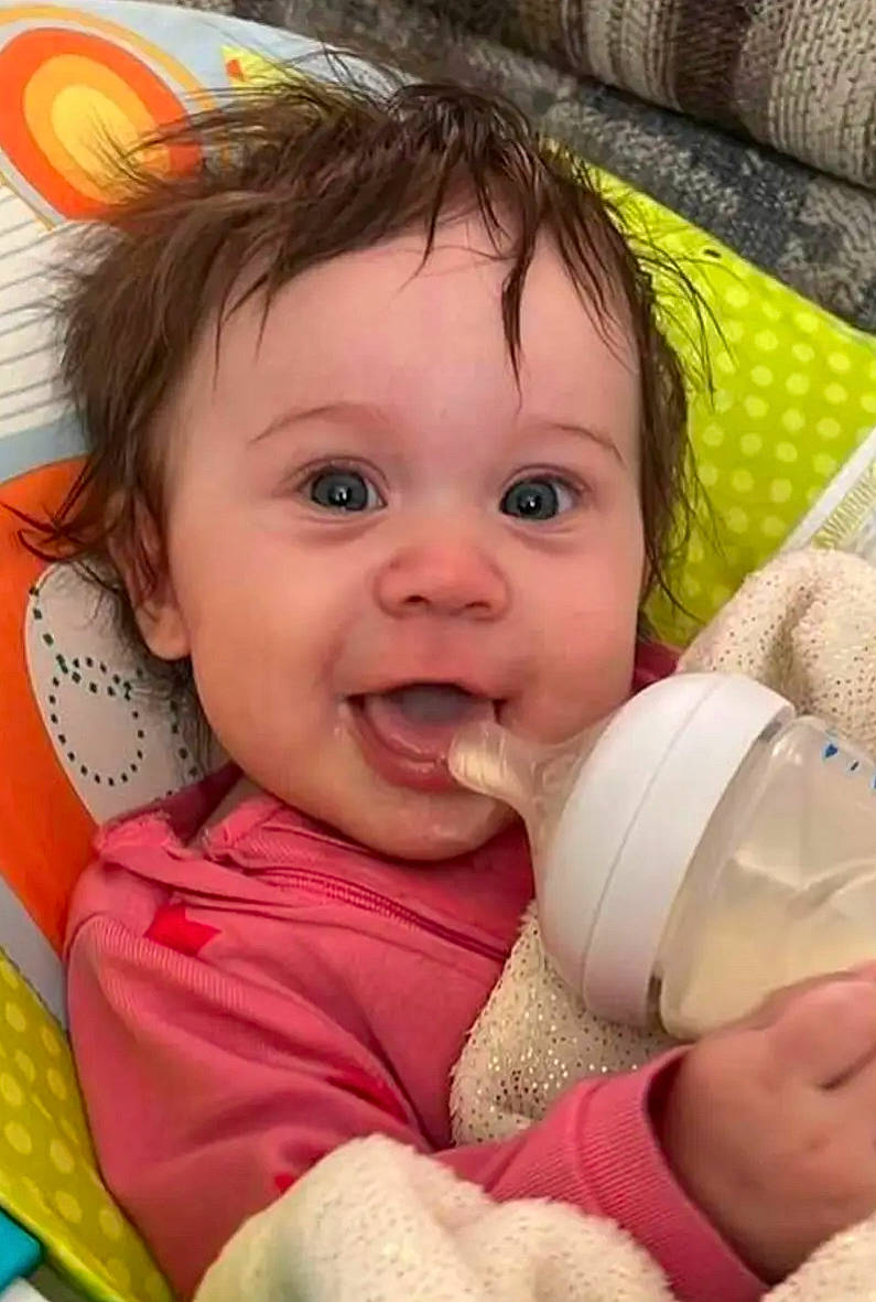 Finley is registered to the contest to win money with this photo: baby, baby_bottle, baby_toddler_clothing, cheek, chin, drinkware, eye, eyebrow, eyelash, facial_expression, gesture, happy, iris, lip, mouth, nose, person, pink, skin, smile