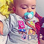 Serenity is registered to the contest to win money with this photo: baby, pacifier, sleeping, child, clothing, cartoon, bed, blanket, plastic_bag, indoor, person, cute, face, head, comfort, toddler, sleeve, pajamas, infant, resting
