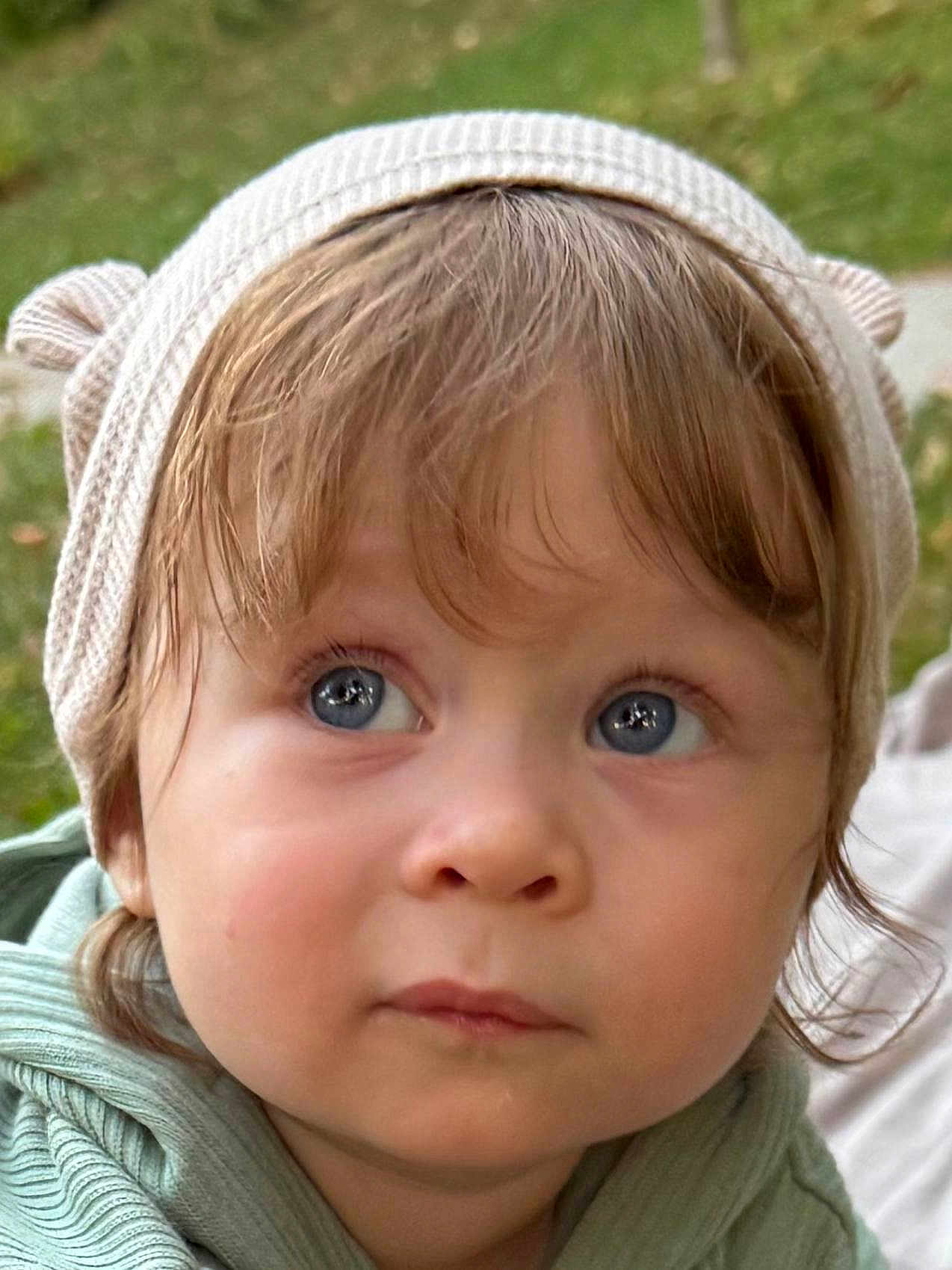 Richard joined the competition — help win amazing prizes! toddler, child, face, blue_eyes, hat, knit_hat, beige_hat, curly_hair, outdoor, portrait, close_up, cute, apparel, headwear, expression, young_child, soft_lighting, nature_background, casual_clothing, curious