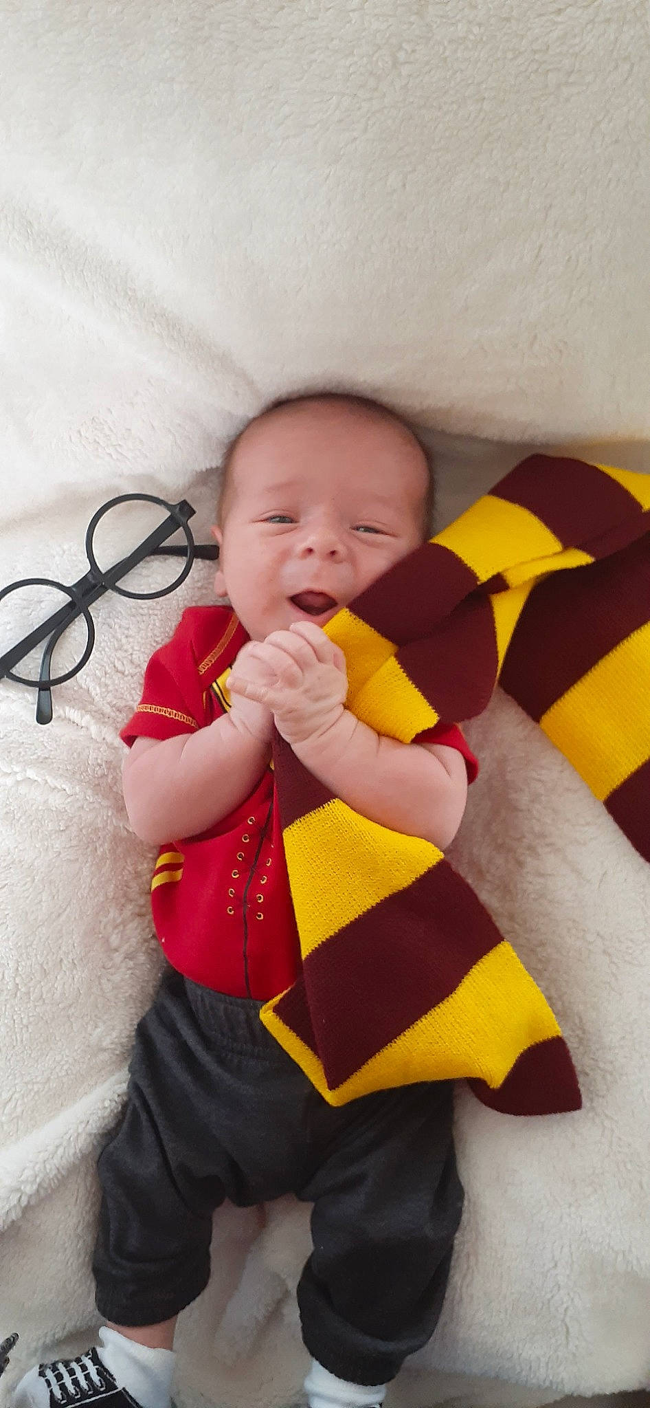 Ares is registered to the contest to win money with this photo: baby, baby_toddler_clothing, cheek, child, comfort, dress, eye, face, finger, happy, head, human_body, human_leg, linens, pattern, person, skin, sleeve, textile, thigh