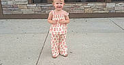 Everly is registered to the contest to win money with this photo: building, car, casual, child, clothing, concrete, daylight, flower_pattern, happy, outdoor, person, pigtails, portrait, reflection, sidewalk, smiling, stone_wall, toddler, urban, window