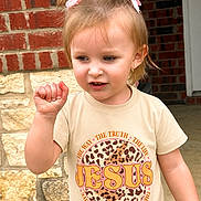 Kodi Sue is registered to the contest to win money with this photo: brick_wall, casual_clothing, child, curious, daylight, gesture, girl, leopard_print, outdoor, person, pigtails, pink_bows, portrait, sidewalk, smile, stone_wall, text, toddler, tshirt, young_child
