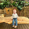 toddler, child, bench, wood, plants, greenery, bamboo_fence, indoor_garden, curious, pink_bow, casual_clothing, jeans, boots, long_sleeve_shirt, portrait, smile, nature, background, floor, wooden_floor