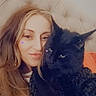 woman, cat, black_cat, pet, selfie, indoor, bed, headboard, long_hair, portrait, cute, heart_sticker, cozy, feline, animal, face, closeup, home, relaxation, friendship