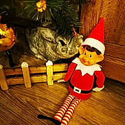 Mr Moustache a rejoint le concours — aidez-le/la à gagner de superbes lots ! animal, christmas_tree, close_up, cozy, curious, decoration, elf, festive, furry, holiday, indoor, ornament, plush_toy, rabbit, red_hat, small, striped_stockings, toy, wooden_fence, wooden_floor