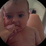 Paisley joined the competition — help win amazing prizes! baby, infant, hand, finger, skin, face, eyes, person, nude, circular_frame, indoor, curious, closeup, expression, cheek, adult_hand, portrait, child, human, interaction