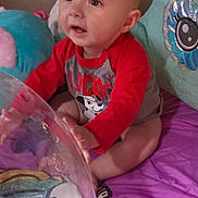Cairo is registered to the contest to win money with this photo: toddler, child, baby, indoor, plush_toy, blanket, purple, red_shirt, curious, sitting, face, person, playful, soft_toys, cute, young_child, expression, home, colorful, engaged