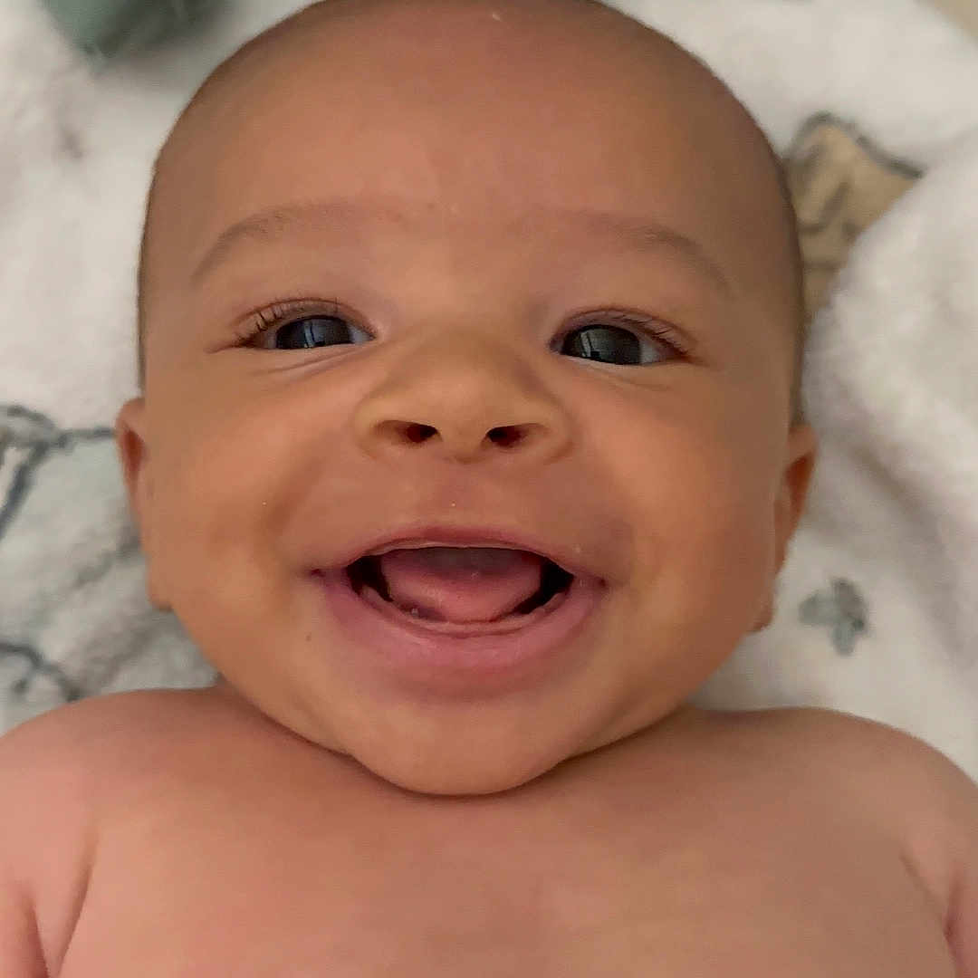 Neurey is registered to the contest to win money with this photo: baby, blanket, casual, cheerful, child, closeup, clothing, cute, expression, face, happy, human, indoors, infant, lying_down, portrait, skin, smiling, soft_texture, young