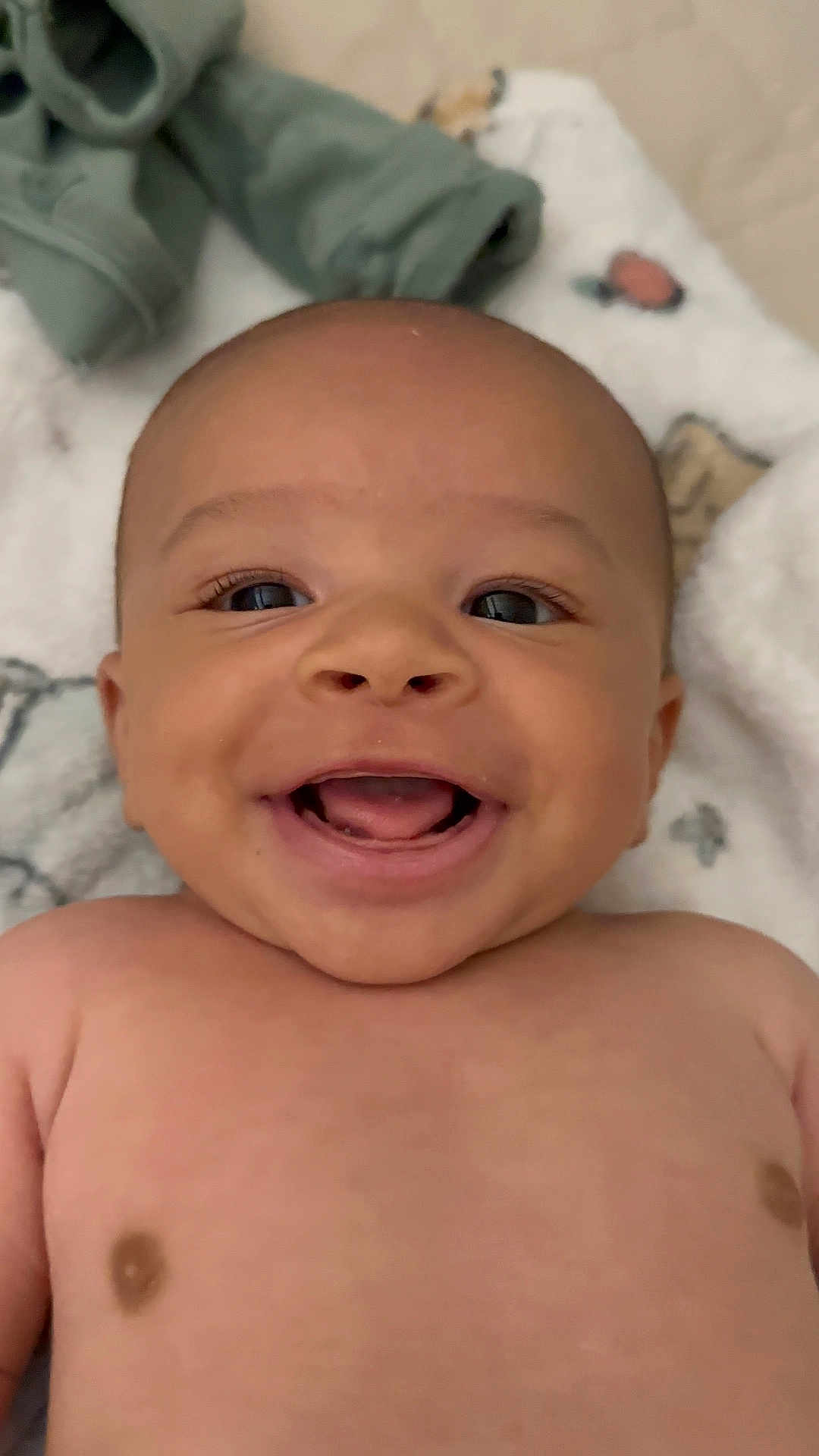 Neurey is registered to the contest to win money with this photo: baby, smiling, face, skin, blanket, happy, infant, child, portrait, cute, cheerful, lying_down, closeup, soft_texture, casual, clothing, expression, human, indoors, young