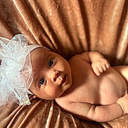 Mia is registered to the contest to win money with this photo: baby, infant, headband, bow, blanket, soft_texture, skin, face, eyes, smile, lying_down, cute, child, newborn, adorable, indoors, portrait, closeup, person, warm_colors
