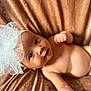 baby, infant, headband, bow, face, skin, eyes, arm, fist, blanket, velvet, cute, portrait, child, newborn, lying_down, soft_texture, indoor, adorable, closeup