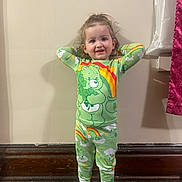 Avery joined the competition — help win amazing prizes! toddler, child, pajamas, green_clothing, rainbow, bear, shamrock, standing, indoor, wall, wooden_floor, smiling, happy, hands_behind_head, orange_socks, cute, portrait, young_child, cozy, casual