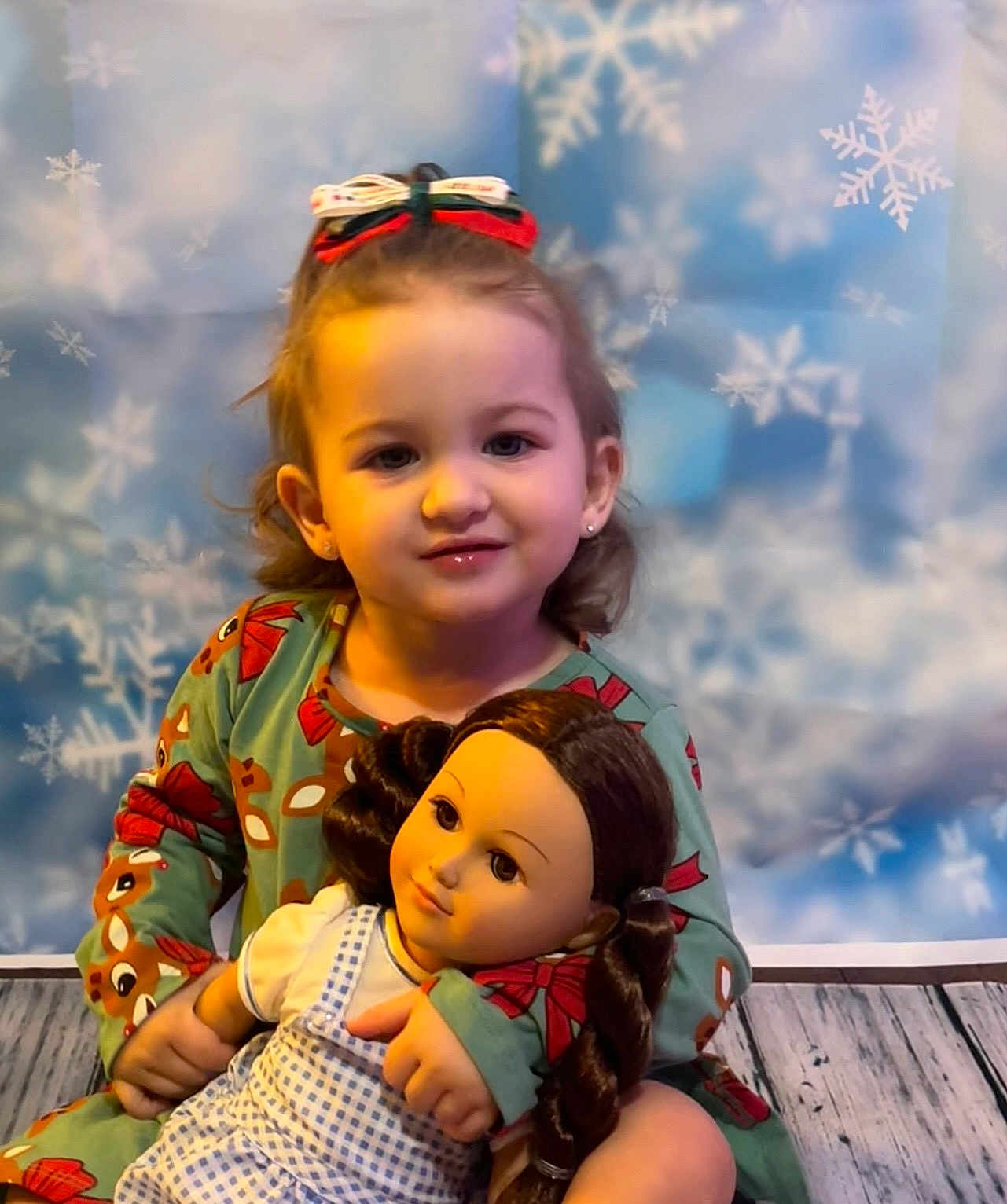 Avery joined the competition — help win amazing prizes! toddler, child, doll, toy, braided_hair, dress, green_clothing, reindeer_pattern, earrings, bow, hair_accessory, smile, indoor, winter_theme, snowflakes, background, floor, portrait, cute, holiday