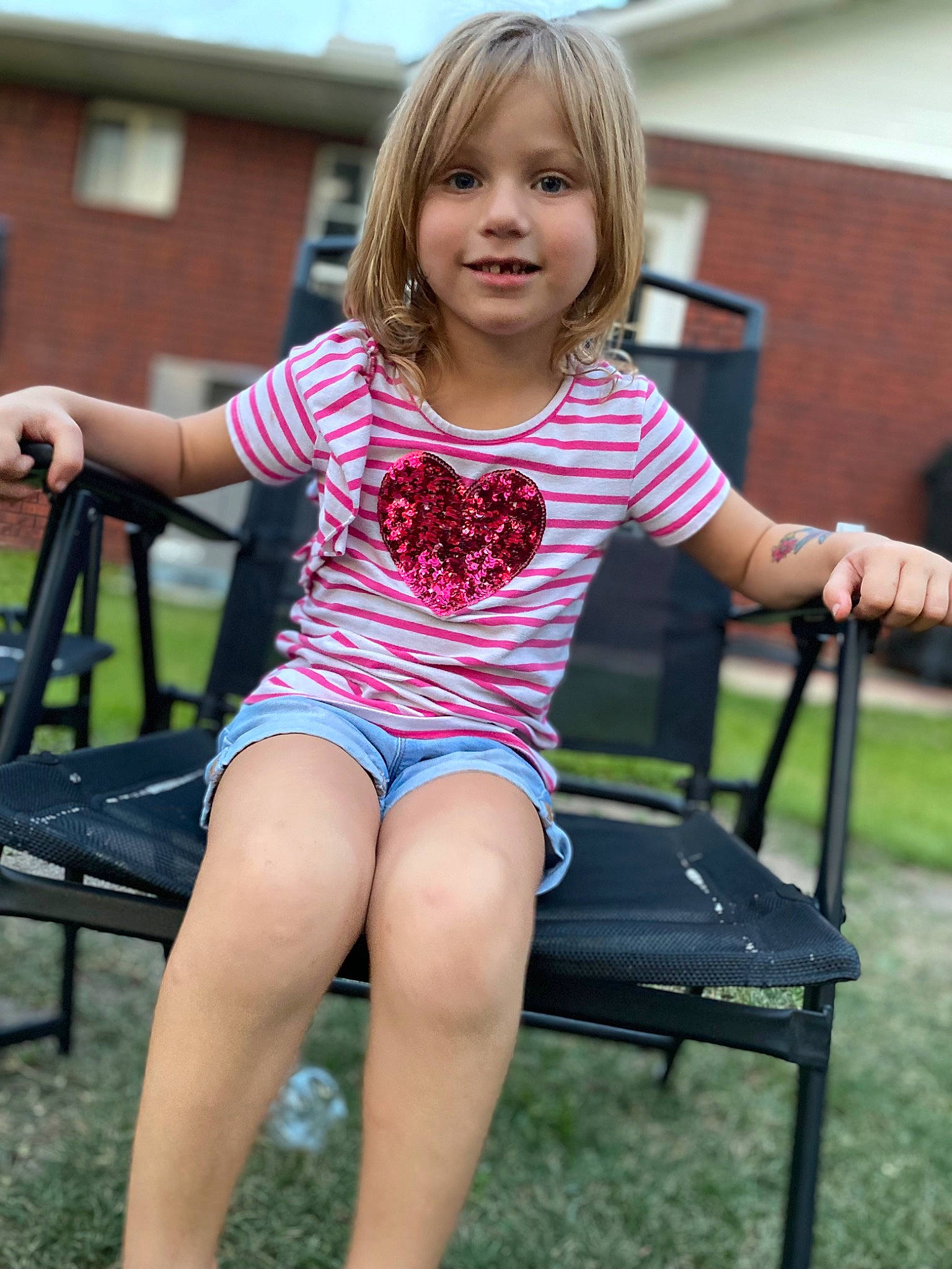 Kenley joined the competition — help win amazing prizes! barefoot, blond, chair, child, dress, finger, fun, grass, happy, human_leg, joy, leisure, magenta, outdoor_furniture, person, shoulder, sitting, skin, smile, thigh