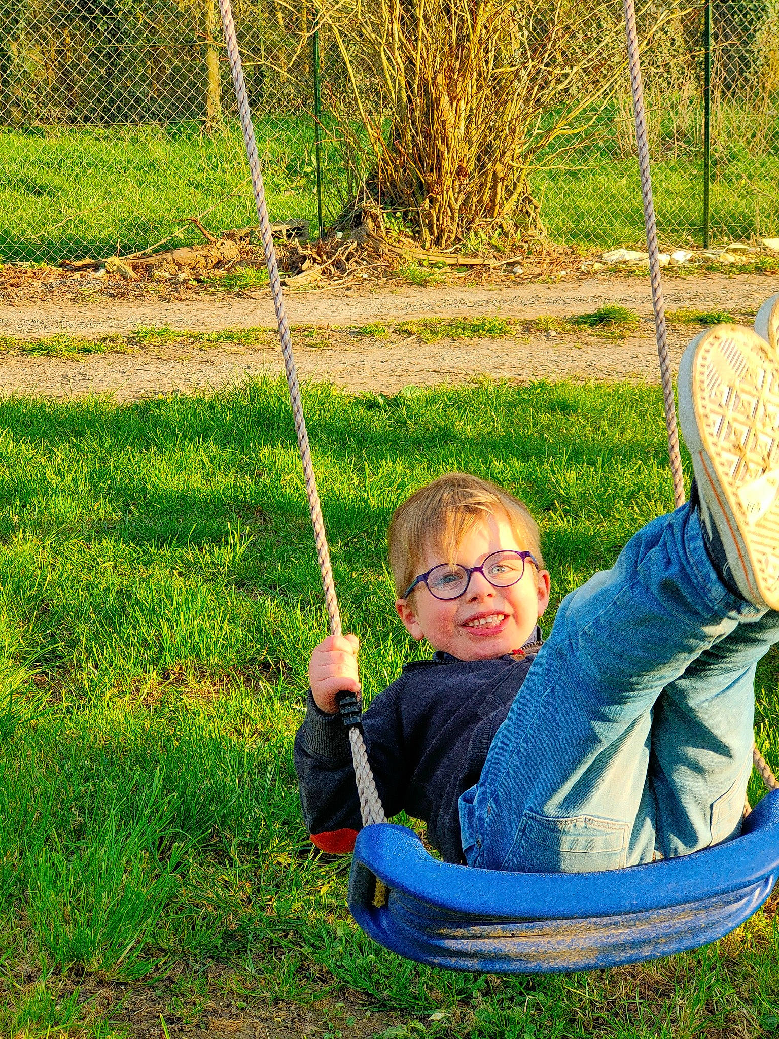 Gabryel a rejoint le concours — aidez-le/la à gagner de superbes lots ! chair, facial_expression, grass, green, happy, joy, leaf, leisure, mammal, morning, nature, people_in_nature, person, photograph, plant, playground, recreation, smile, swing, toddler