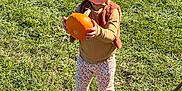 Zarra is registered to the contest to win money with this photo: child, toddler, pumpkin, grass, outdoor, smiling, autumn, fall, clothing, vest, pants, shoes, person, nature, sunlight, harvest, cute, seasonal, greenery, holding