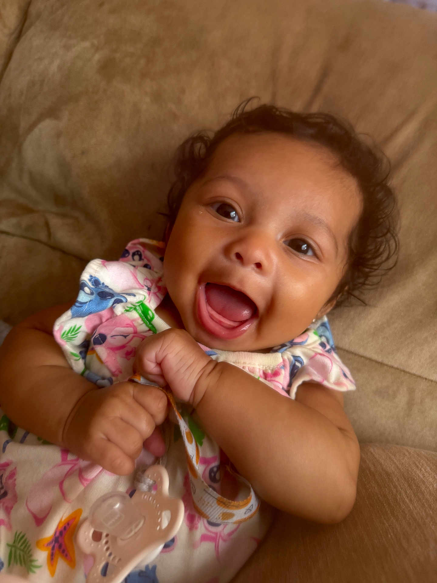 Ariella joined the competition — help win amazing prizes! baby, smiling, pacifier, infant, cute, happy, child, face, clothing, hand, skin, indoors, lying_down, closeup, portrait, expression, young, person, curly_hair, colorful