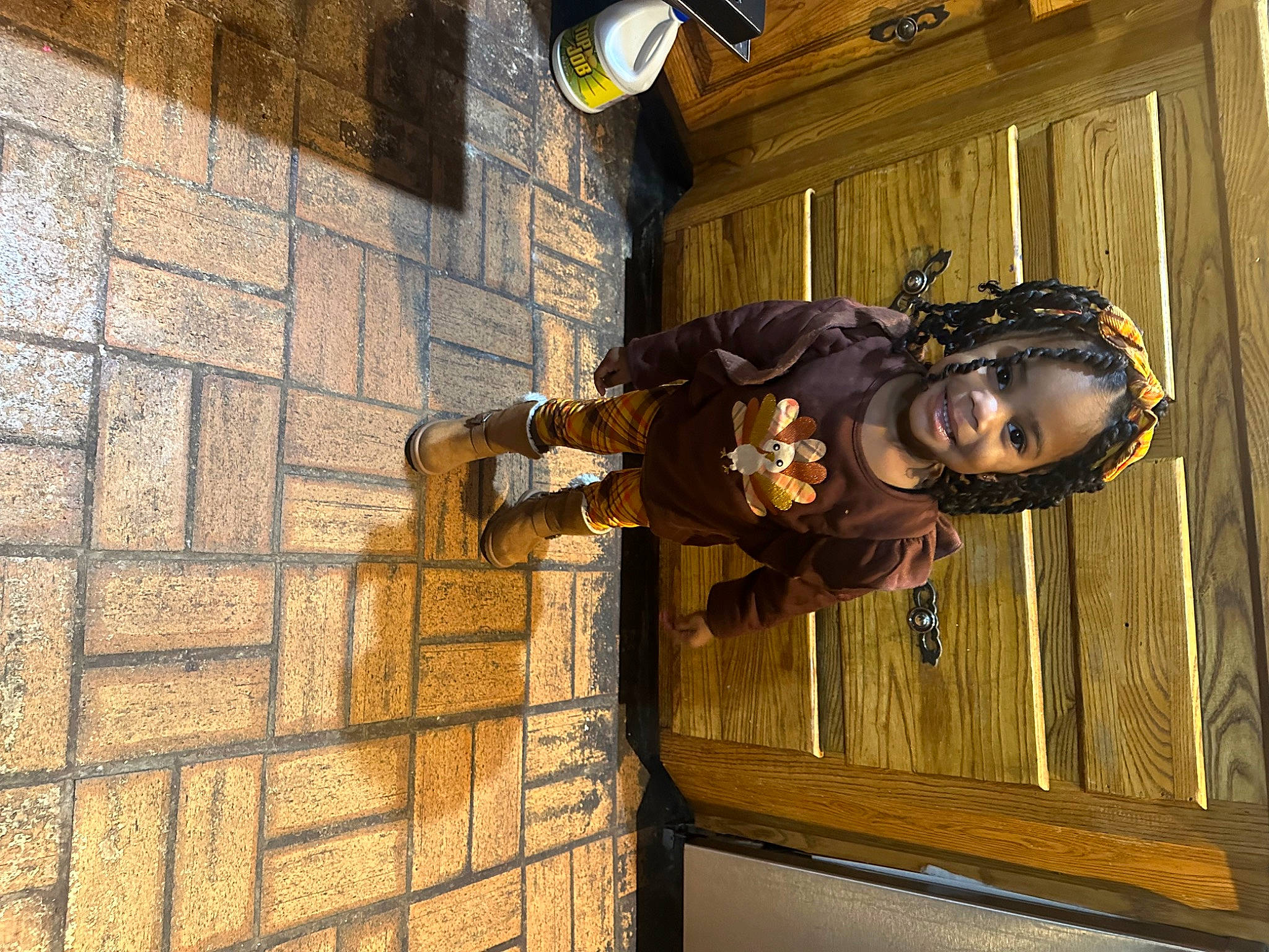 Maliyah is registered to the contest to win money with this photo: bag, bicycle_helmet, brick, brickwork, door, eyewear, facade, fun, goggles, happy, hat, helmet, joy, metal, person, personal_protective_equipment, smile, sunglasses, toddler, window