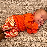 Raven Eclipse joined the competition — help win amazing prizes! baby, blanket, brown_shoes, child, closed_eyes, cozy, curled_up, face, indoor, infant, lying_down, orange_clothing, peaceful, photography, portrait, sleeping, smiling, striped_pants, textured_fabric, warm_colors