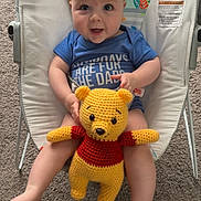Brayden joined the competition — help win amazing prizes! baby, bouncer, plush_toy, crocheted, winnie_the_pooh, carpet, blue_shirt, indoor, child, smiling, sitting, toy, cute, infant, person, face, legs, feet, happy, colorful