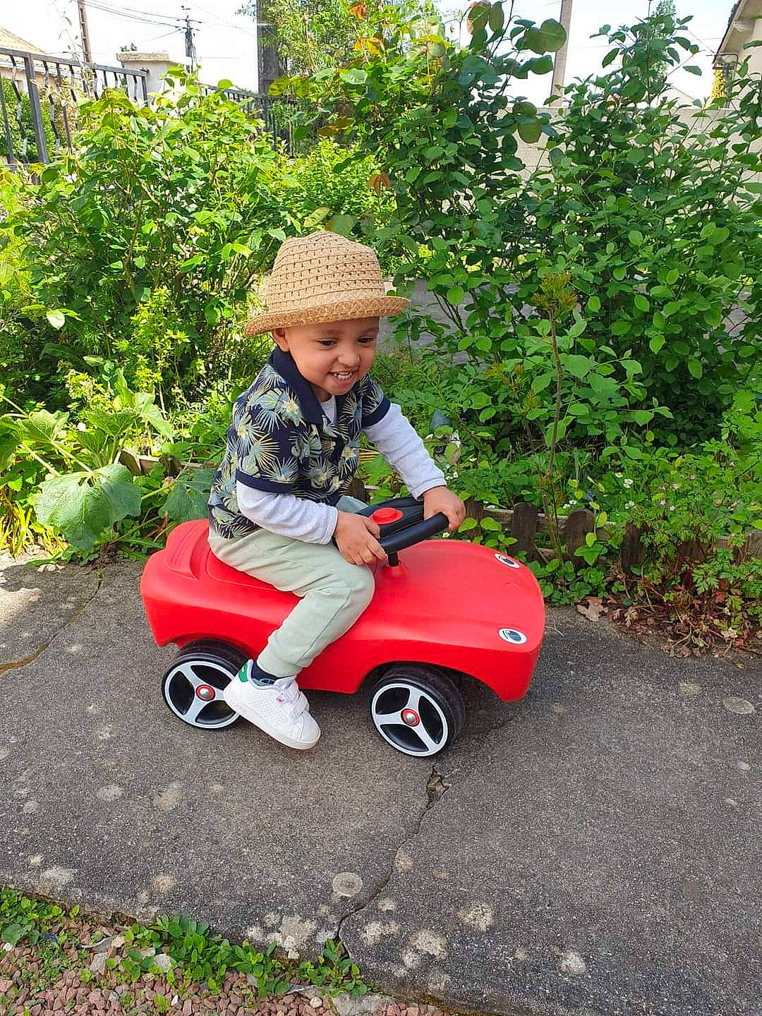 Leeroy participe au concours pour gagner de l'argent avec cette photo : asphalt, automotive_wheel_system, baby_toddler_clothing, garden, grass, hat, headwear, helmet, lawn, leisure, people_in_nature, person, plant, recreation, riding_toy, rolling, shrub, sitting, tire, toddler