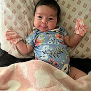 Analeia joined the competition — help win amazing prizes! baby, infant, pillow, blanket, mittens, floral_clothing, patterned_pillow, soft_blanket, cute, smile, lying_down, indoor, child, person, young, cozy, face, head, comfort, resting