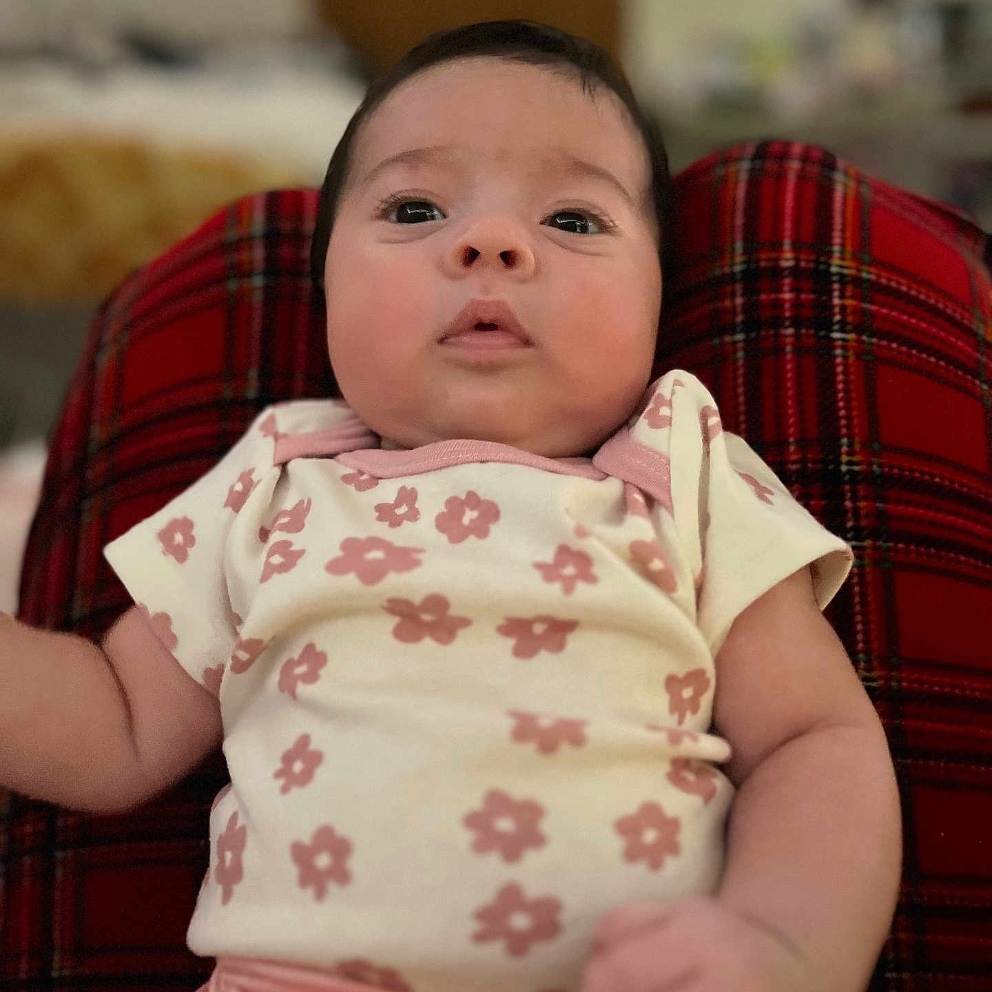 Analeia joined the competition — help win amazing prizes! baby, infant, child, floral_clothing, pink_clothing, plaid_blanket, red_blanket, face, eyes, arm, indoors, blurred_background, cute, expression, newborn, skin, person, lying_down, portrait, soft_lighting