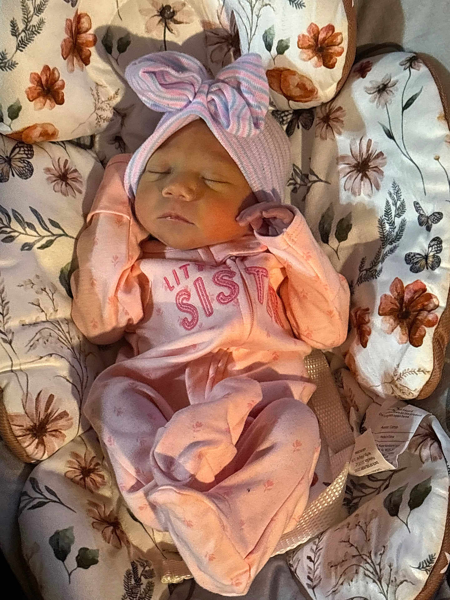 Sarah is registered to the contest to win money with this photo: newborn, baby, sleeping, pink_clothing, headwear, bow, floral_pattern, cushion, infant, cute, peaceful, child, soft_lighting, baby_girl, portrait, indoors, closeup, comfortable, resting, wrapped