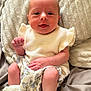 Esmé is registered to the contest to win money with this photo: baby, infant, child, cushion, blanket, clothing, white, frilly, socks, cute, portrait, smiling, indoors, soft_texture, comfort, resting, skin, hand, legs, expression