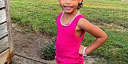 Ava joined the competition — help win amazing prizes! child, girl, outdoor, grass, concrete, sidewalk, pink_clothing, sneakers, bracelet, necklace, hair_accessory, smiling, standing, earrings, pose, sunny, daylight, yard, shed, nature