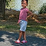 Ava is registered to the contest to win money with this photo: child, girl, smiling, standing, outdoor, lake, water, tree, grass, sunlight, shadow, pink_shoes, shorts, striped_shirt, nature, happy, summer, casual_clothing, portrait, daytime
