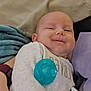 Jayce is registered to the contest to win money with this photo: baby, infant, smile, pacifier, blanket, pajamas, cozy, indoors, cushion, child, person, cute, soft, comfort, resting, closeup, face, happy, relaxed, sleepwear