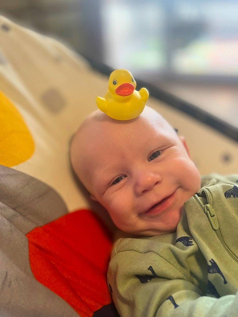 Gunnar is registered to the contest to win money with this photo: baby, baby_toddler_clothing, bath_toy, cheek, child, comfort, eye, facial_expression, finger, fun, happy, nose, orange, person, product, rubber_ducky, skin, smile, toddler, toy
